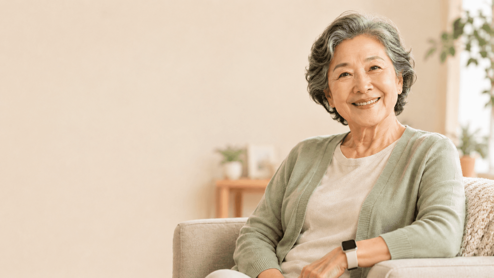 An older woman smiling warmly while wearing a smartwatch at home.